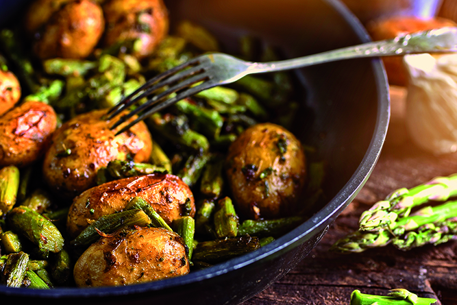 asparagus with potatoes fried in a pan with herbs