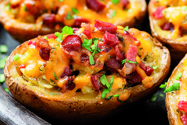 Hot baked potato topped with bacon, green onions and cheddar che