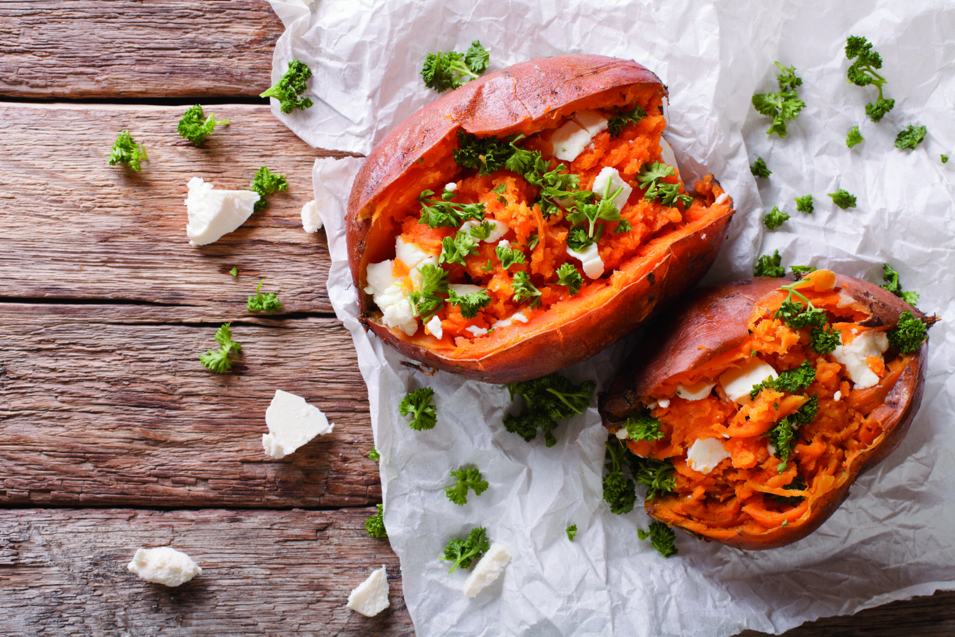 sweet potatoes baked with feta cheese and parsley on the table.