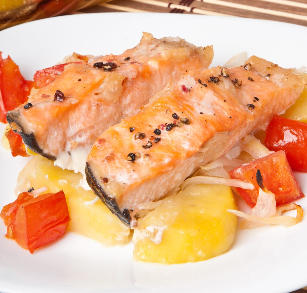Pieces of salmon with potatoes, tomatoes and onions baked in the oven