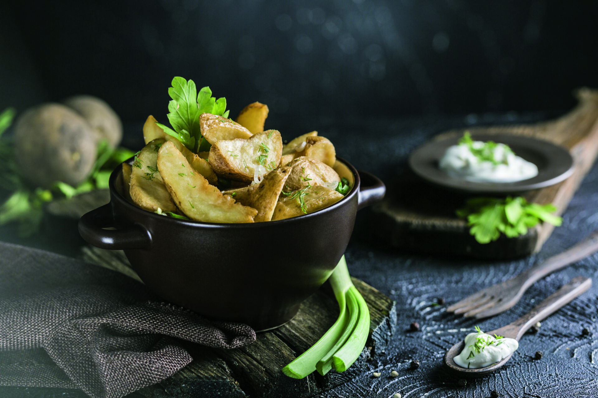 Baked potatoes and green onions, garlic and sour cream in a cera