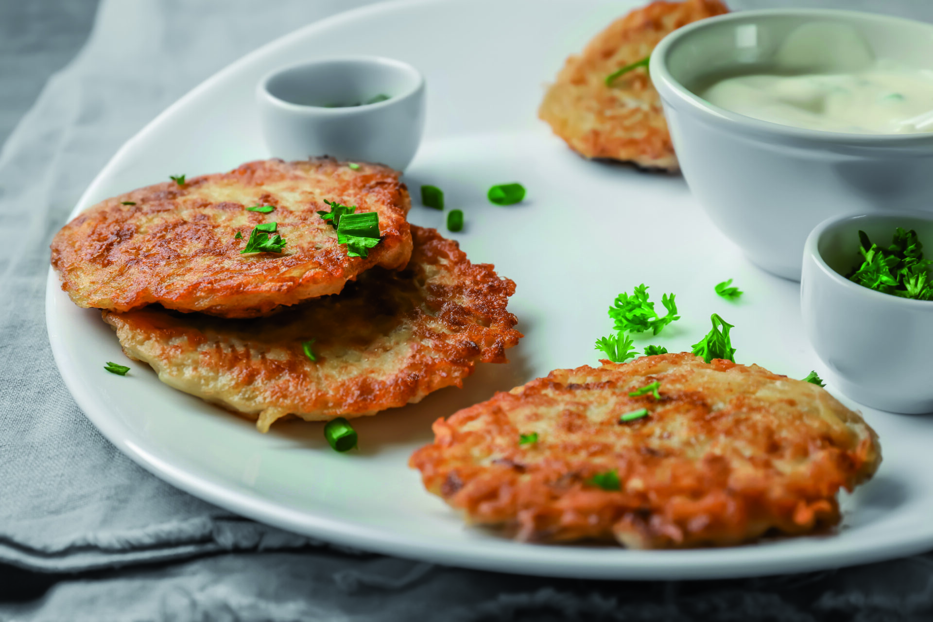 Plate with Hanukkah potato pancakes on table, closeup